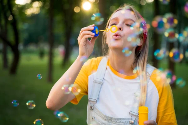 front-view-woman-playing-outdoors-with-bubbles
